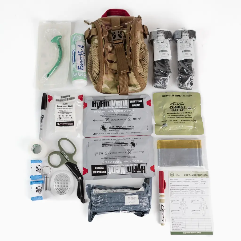 A professionally configured IFAK Individual First Aid Kit open to show trauma contents including tourniquet, hemostatic gauze, and chest seals
